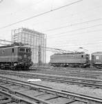859418 Afbeelding van de electrische locomotieven nrs. 1138 (links) en 1101 (serie 1100) van de N.S. te Amsterdam C.S.